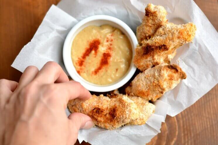 fingers picking up chicken fingers