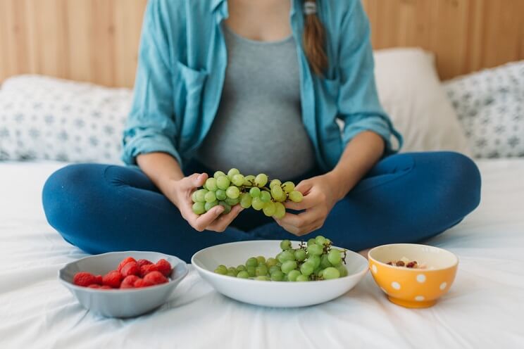 pregnant woman eating fruit