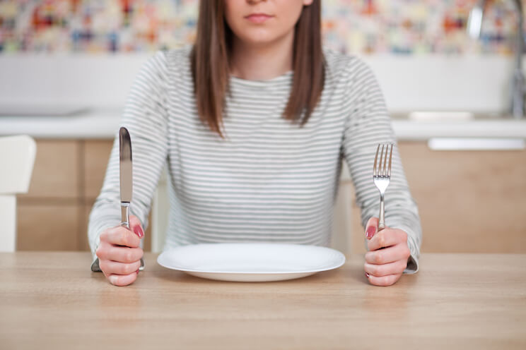 Hungry woman with a fork and spoon
